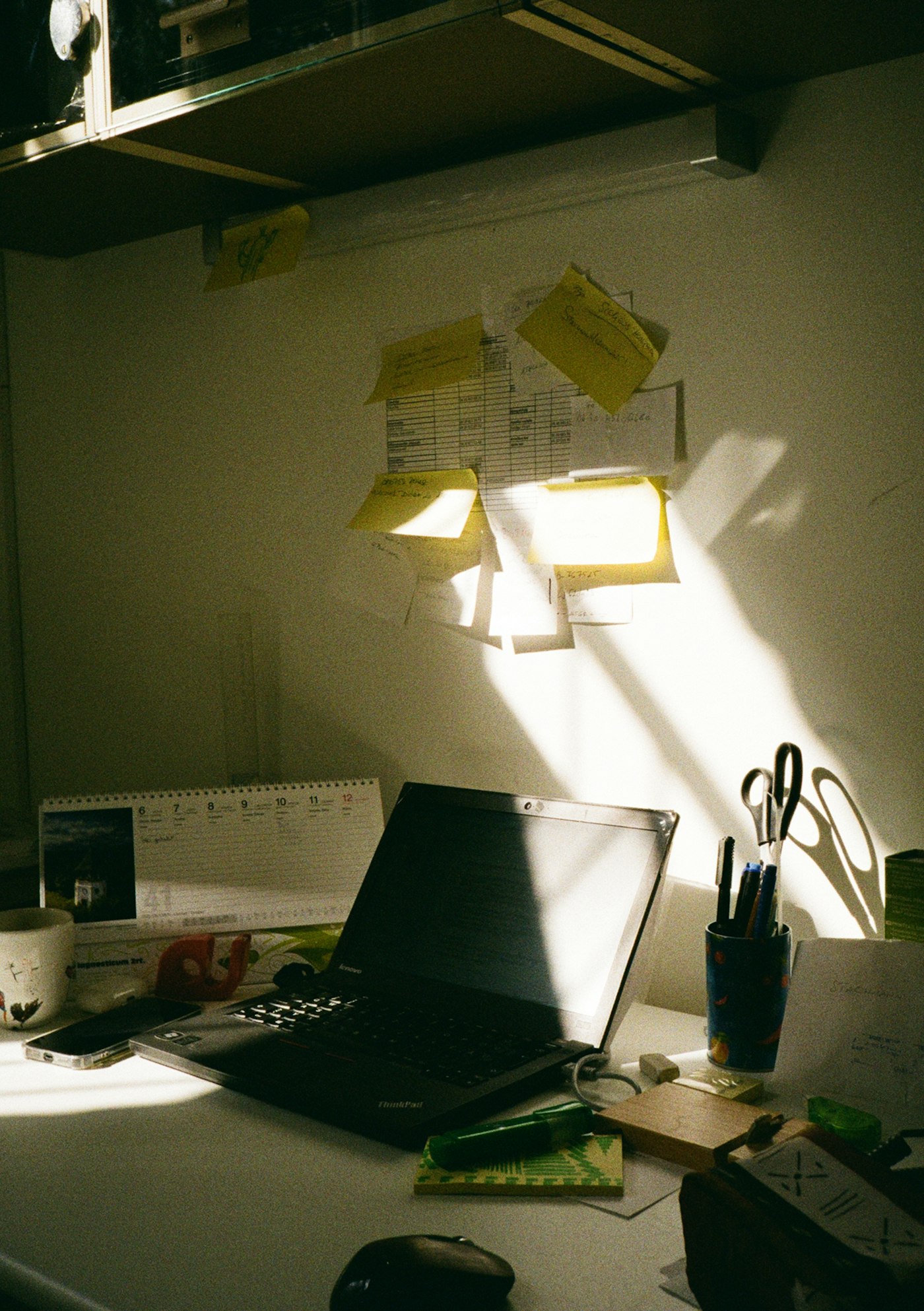 Desk covered in sticky notes and paperwork